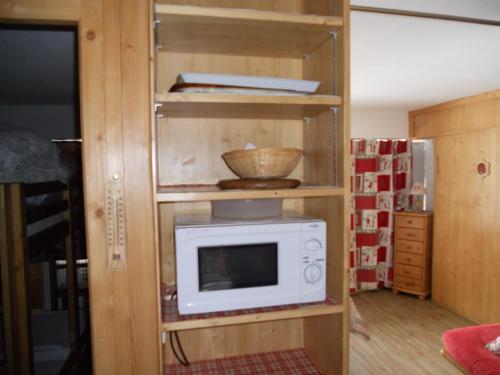 un four micro-ondes sur une étagère dans une chambre dans l'établissement Les MENUIRES la Croisette Appt 6 pers Coeur de station, aux Menuires