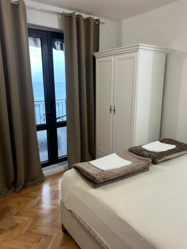 a bedroom with two beds and a large window at Apartments Dijana in Kotor