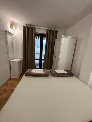 a bedroom with two beds in front of a window at Apartments Dijana in Kotor