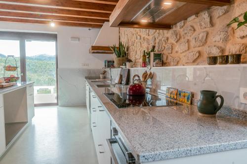 a kitchen with marble counter tops and a stone wall at Olabe in Ea