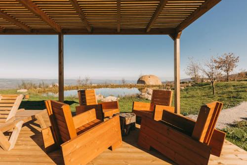 a group of wooden chairs sitting on a deck at Estrela Serenity - Resort in Folgosinho