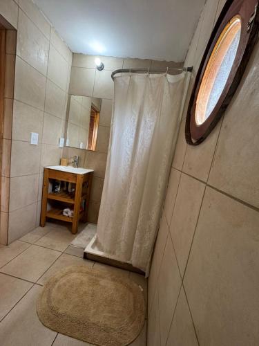 een badkamer met een douchegordijn en een wastafel bij AMARRA Camet Norte in Camet Norte