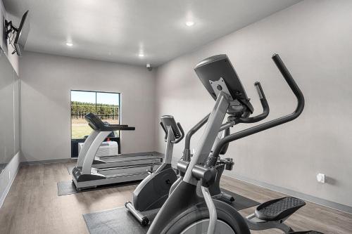 a gym with two exercise bikes and a treadmill at Riverstone Suites by Cobblestone Hotels - Chippewa Falls in Chippewa Falls