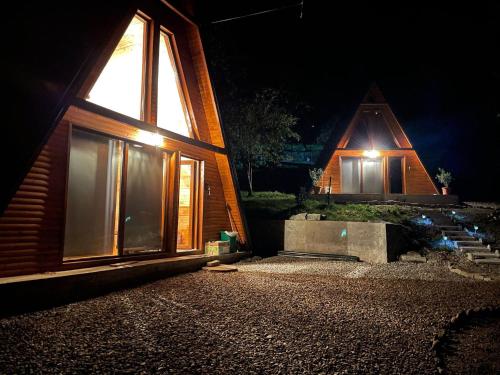 a house with a lit up window at night at Rubicon Cabins in Secăria