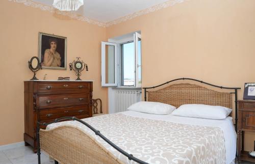 a bedroom with a bed and a dresser and a window at Casale Conca dei Sogni in Conca della Campania