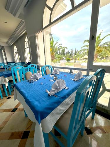 a table with blue chairs and a blue table cloth at Hôtel Green Golf Hammamet in Hammamet
