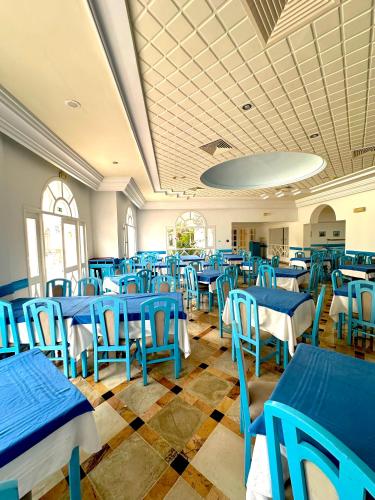 a dining room with blue tables and chairs at Hôtel Green Golf Hammamet in Hammamet