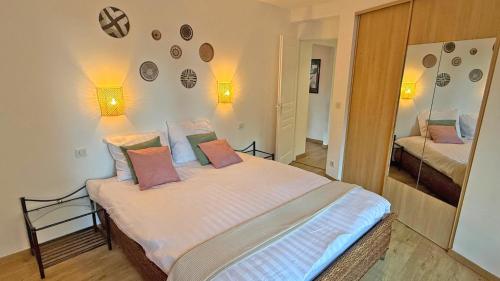 une chambre avec un lit avec des oreillers roses dessus dans l'établissement Suffren E28, à Sainte-Maxime