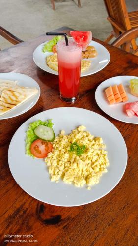 une table avec des assiettes de nourriture et une boisson dans l'établissement JinengBali Eco Lodge, à Tegalalang