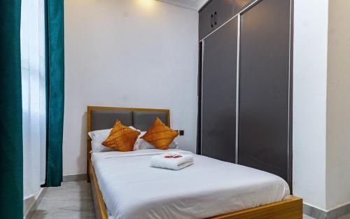 a bedroom with a bed with orange pillows at Emerald by Skyline Villa in Lotus Island