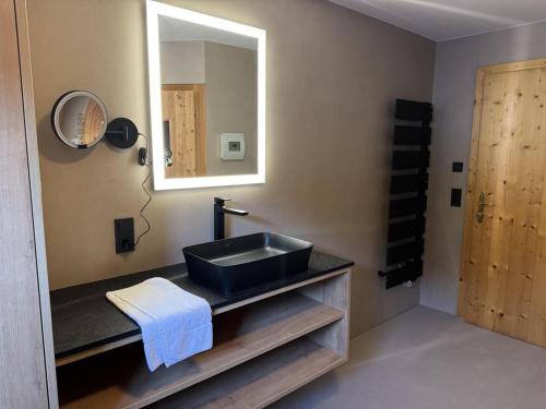 a bathroom with a black sink and a mirror at Schöneben Chalet MilKa in Wald im Pinzgau