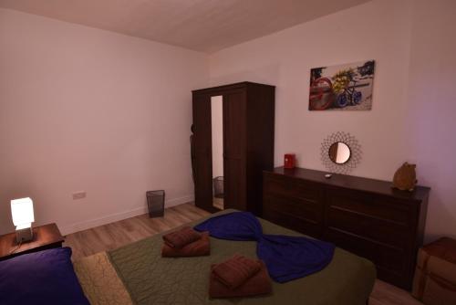 a bedroom with a bed and a dresser and a mirror at Sea Breeze Nest in St Paul's Bay
