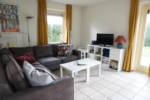 a living room with a couch and a tv at Kustverhuur, Park Schoneveld, Zeemeeuw 164 in Breskens