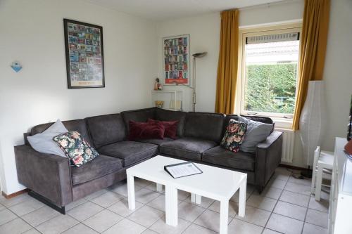 a living room with a couch and a table at Kustverhuur, Park Schoneveld, Zeemeeuw 164 in Breskens