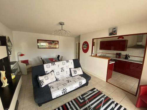un salon avec un lit et une cuisine dans l'établissement Résidence l'ACCALMIE- Appartement pour 4 personnes proche du port de pêche, à Capbreton