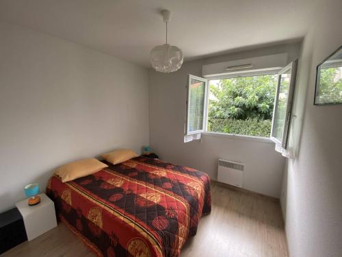 une chambre avec un lit et une fenêtre dans l'établissement Résidence l'ACCALMIE- Appartement pour 4 personnes proche du port de pêche, à Capbreton