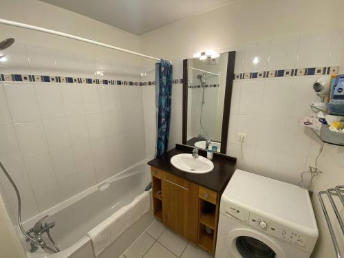 une salle de bain avec un lavabo et une machine à laver dans l'établissement Résidence l'ACCALMIE- Appartement pour 4 personnes proche du port de pêche, à Capbreton