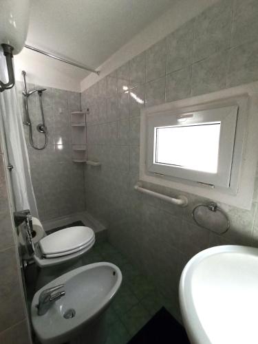 a bathroom with a sink and a toilet and a window at Alloggio Turistico Casina Margherita in Roccalvecce
