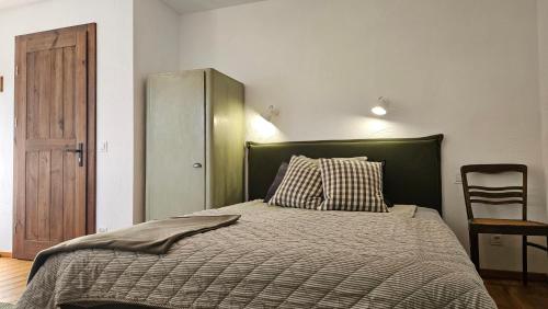 a bedroom with a bed with a green headboard and a chair at Miodówka in Stronie Śląskie