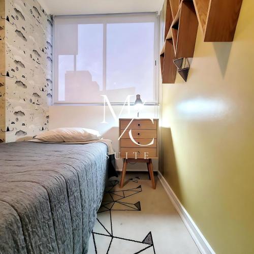 アントファガスタにあるDepartamento ejecutivo 2 habitaciones Centralのベッドと机と窓のある寝室