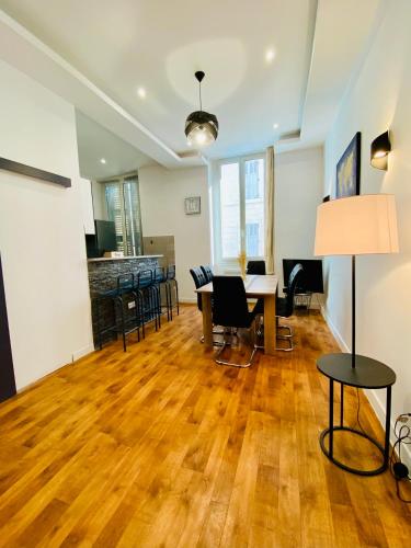 - un salon doté de parquet, d'une table et de chaises dans l'établissement Le Méditerranéen - 5 personnes - Vieux Port, à Marseille
