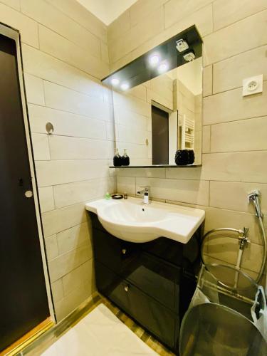 une salle de bain avec un lavabo et un miroir dans l'établissement Le Méditerranéen - 5 personnes - Vieux Port, à Marseille
