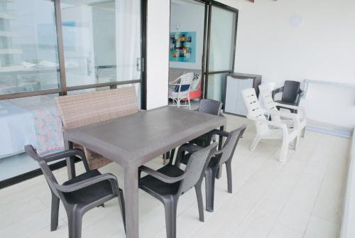 a dining room with a wooden table and chairs at Bay Point- Ocean View Apartments by NIDHO PROPERTIES in San Andrés