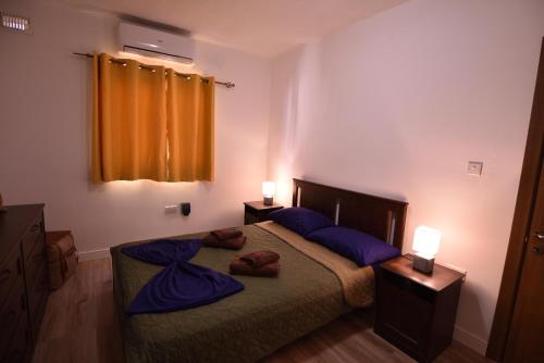 a bedroom with a bed with purple sheets and two lamps at Sea Breeze Nest in St Paul's Bay