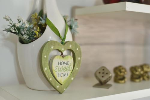 a green heart ornament on a shelf with a vase at Sea Breeze Nest in St Paul's Bay