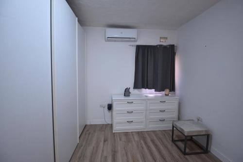 a bathroom with a white dresser and a sink at Sea Breeze Nest in St Paul's Bay