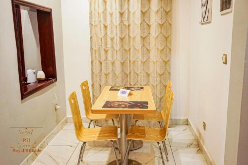 a dining table and chairs in a room at Royal Hillside Apartments and Hotels in Yaoundé