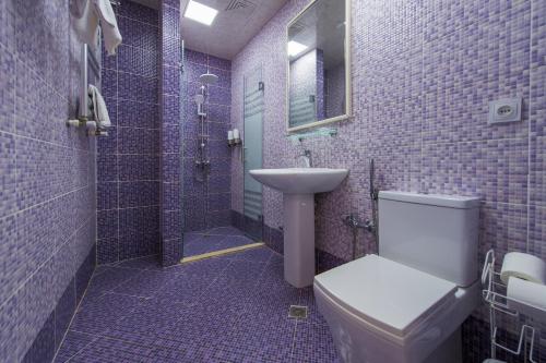 a bathroom with a toilet and a sink and a shower at Two Seasons Boutique Hotel Baku in Baku
