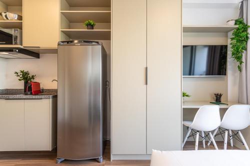 a stainless steel refrigerator in a kitchen with white cabinets at Hub Boa Vista by Viva - Prédio novo próximo ao Autódromo de Interlagos com lavanderia e academia in Sao Paulo