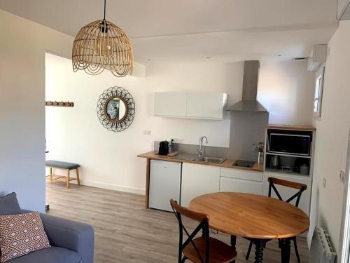 une cuisine et une salle à manger avec une table dans une pièce dans l'établissement Chez Rose, Terrasse Plein Sud!, à Donville-les-Bains