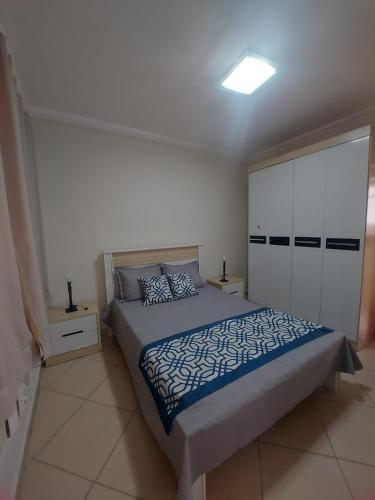 a bedroom with a bed and a white cabinet at santos gonzaga frente pro mar in Santos