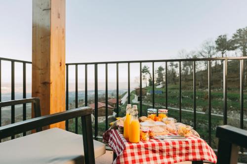 a table with food and orange juice on a balcony at Estrela Serenity - Resort in Folgosinho