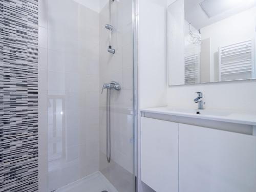 une salle de bain blanche avec une douche et un lavabo dans l'établissement La Dune N 53 - Villa 3P6, à Sérignan