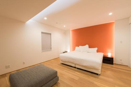 a bedroom with a white bed and a chair at Yuzuki in Kutchan