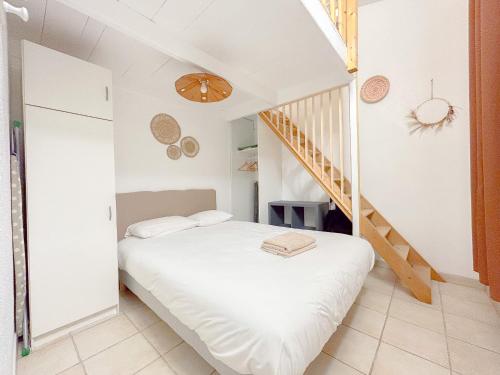 une chambre avec un lit et un escalier dans l'établissement Charmant Mas centrale, bord de mer cour intérieur idéal pour 4 personnes, à Fréjus