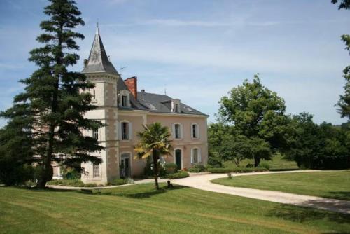 Une grande maison blanche avec une tour en haut dans l'établissement Le Château de Monciaux, à Bourrou