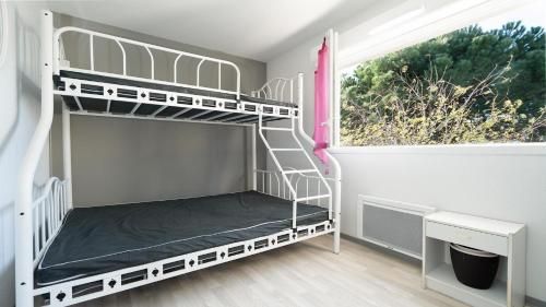 une chambre avec deux lits superposés et une fenêtre dans l'établissement La Dune N 08 - Villa 4P8, à Sérignan