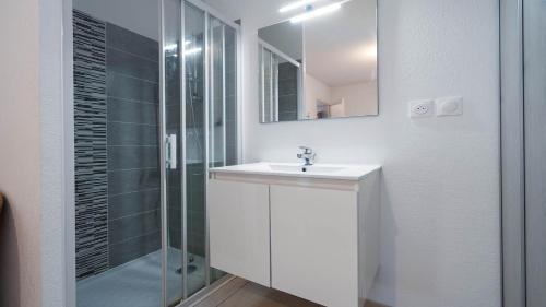 une salle de bain blanche avec un lavabo et une douche dans l'établissement La Dune N 08 - Villa 4P8, à Sérignan