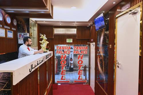 a man standing at a bar in a restaurant at Tanha Palace Hotel in Dubai