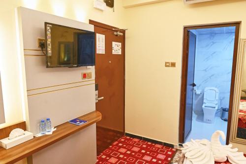 a bathroom with a refrigerator and a toilet at Tanha Palace Hotel in Dubai
