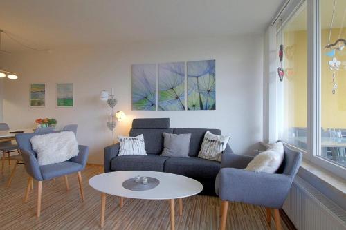 een woonkamer met een bank, stoelen en een tafel bij Apartment 238 in Hohegeiß