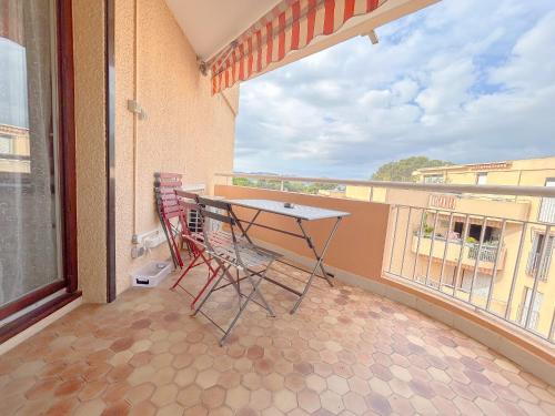 un balcon avec une table et des chaises et une grande fenêtre dans l'établissement Appartement Port santa lucia, palais des congres avec garage ferme, à Saint-Raphaël