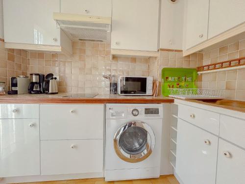 une cuisine avec un lave-linge et un micro-ondes dans l'établissement Appartement Port santa lucia, palais des congres avec garage ferme, à Saint-Raphaël