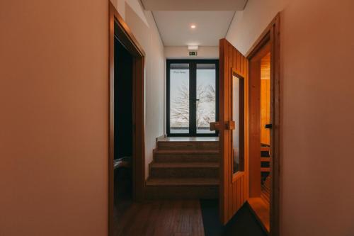 a hallway with stairs and a window in a house at Estrela Serenity - Resort in Folgosinho