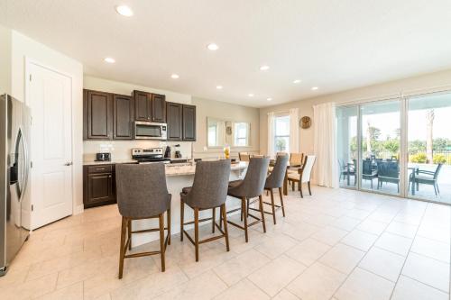 a kitchen with a large island with bar stools at Charming Home With Private Pool Near Disney With Water Park & Resort Access At Encore Resort - 7489Mr in Kissimmee