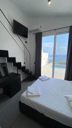 a bedroom with a bed and a staircase with a view at Akrogiali Apartments in Barbati